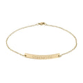 Gold bracelet with 'STRENGTH' engraving on a white background